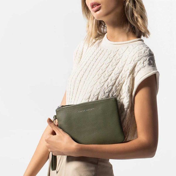 woman showing the front of the status anxiety Khaki Fixation Clutch