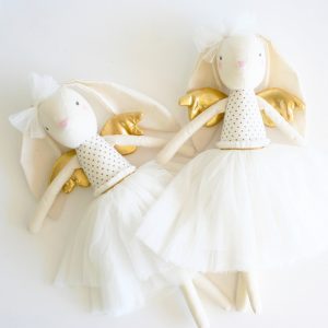 two alimrose gold angel bunny dolls laying next to eachother on a white table