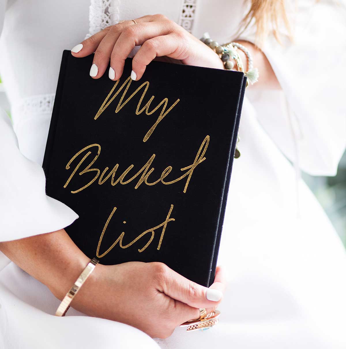 lady in white dress holding a bucket list book
