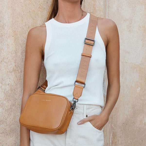 woman wearing status anxiety tan plunder bag across her body